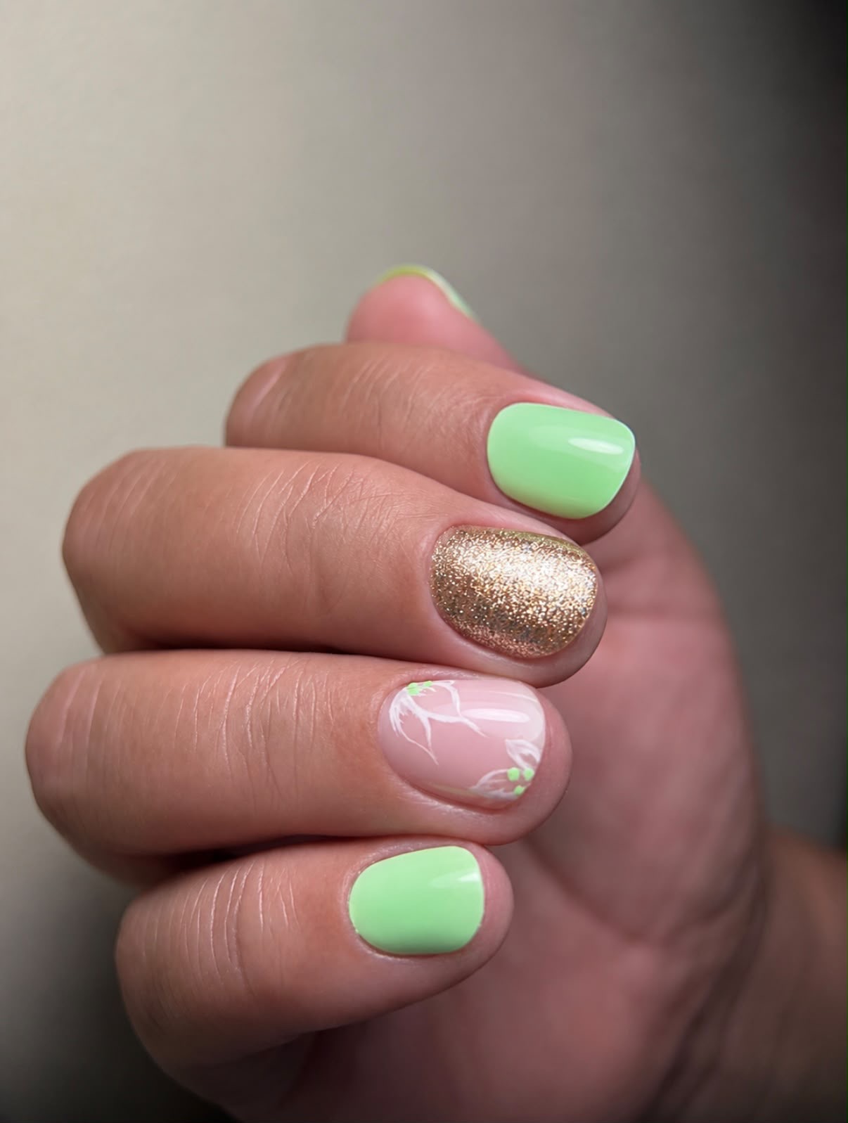 Manucure vert tendre, doré et motif floral